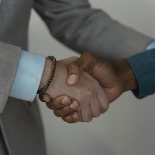 Two hands shaking to indicate agreement and collaboration.